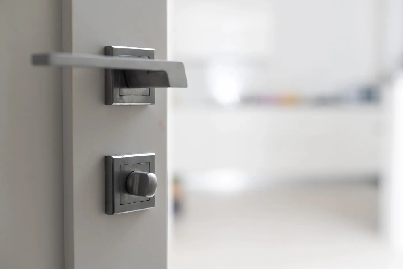 Détail d'une poignée et d'un verrou de porte rénovés dans un logement du quartier Clignancourt (75018)